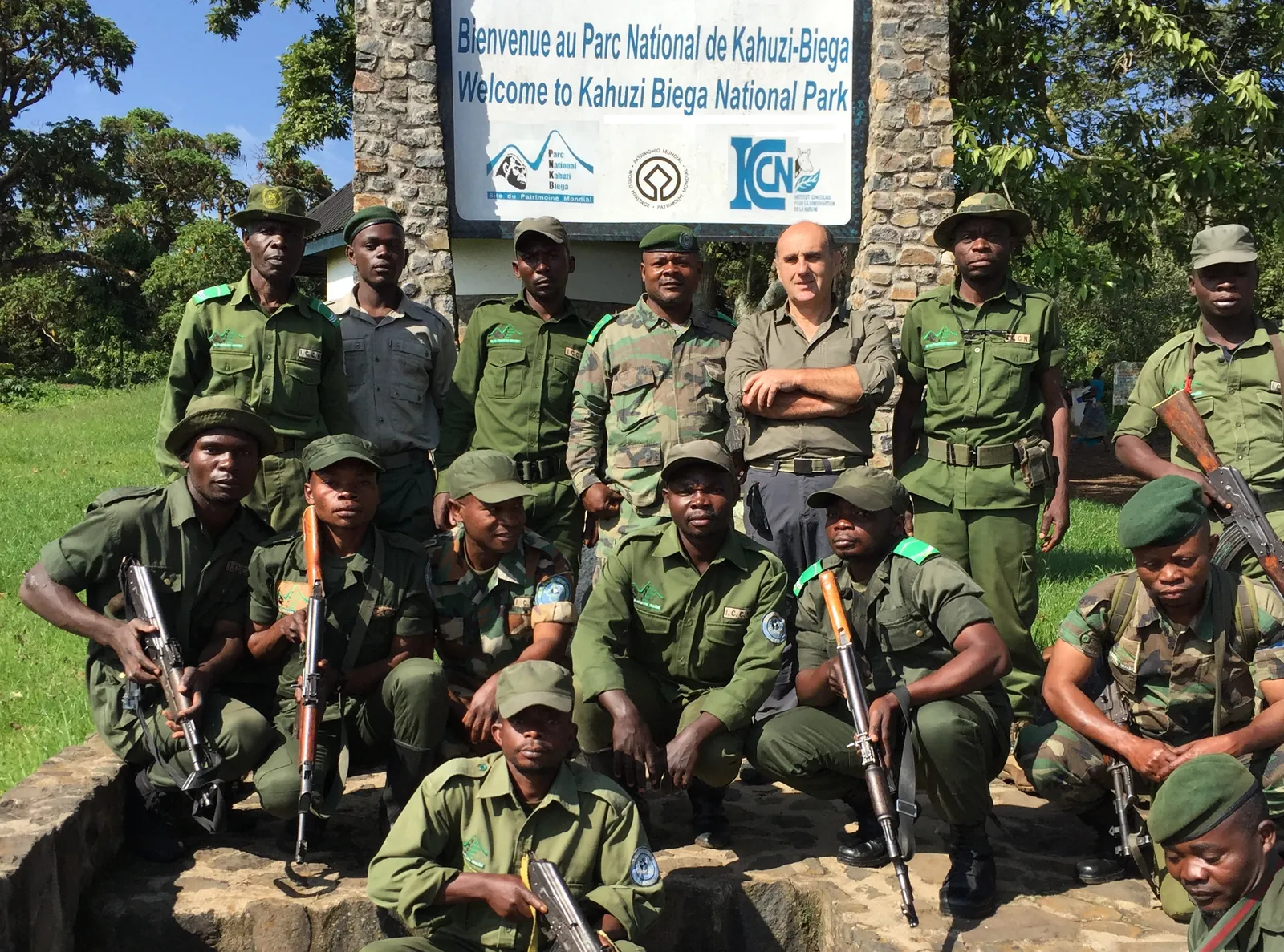 Groupe d'écogardes devant le panneau d'accueil du parc national de Kahuzi-Biega
