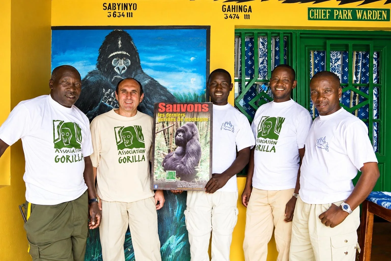 Fabrice Martinez et quatre membres de l'équipe, en t-shirts Association Gorilla, tenant l'affiche Sauvons les derniers gorilles de montagne