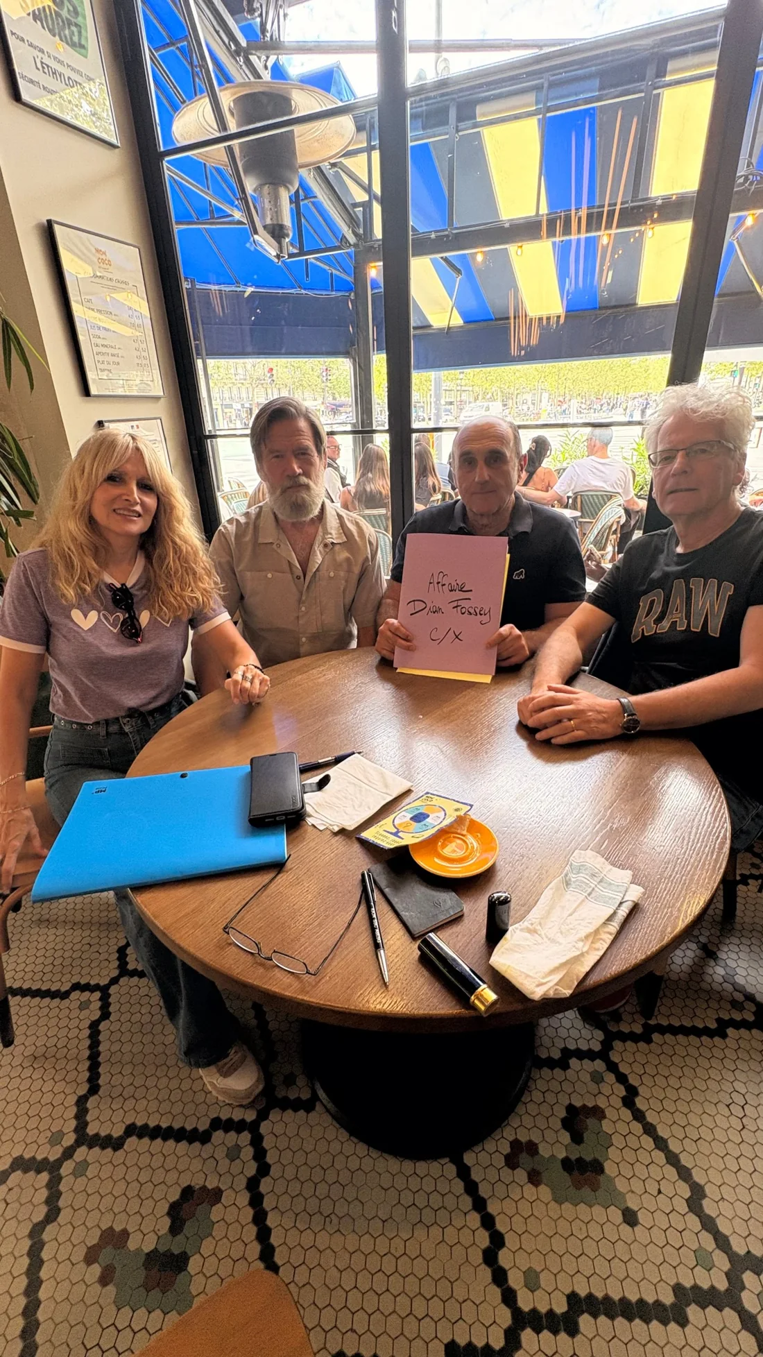 Maria-José Sanchez, Ian Redmond, Fabrice Martinez et Philippe Bertrand autour d'une table de café, Fabrice Martinez tenant une chemise intitulée Affaire Dian Fossey